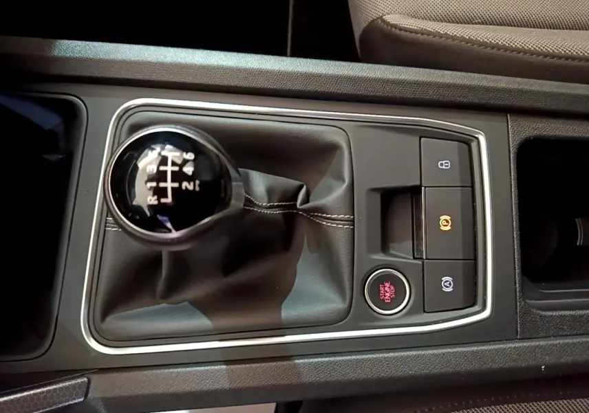 Vue rapprochée de la console centrale grise avec levier de vitesse manuel et bouton start/stop du SEAT Leon 2023.