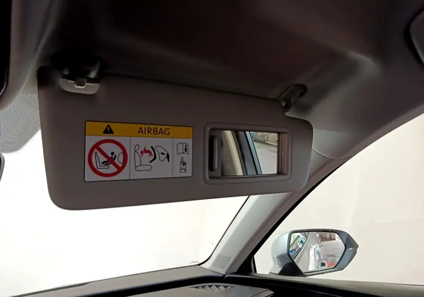 Détail du pare-soleil côté conducteur avec miroir et avertissement airbag dans un SEAT Leon gris foncé 2023.