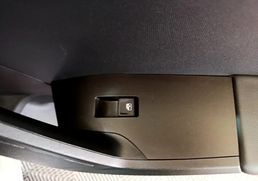 Bouton de commande de lève-vitre côté gauche intérieur d'une SEAT Leon gris foncé 2023.