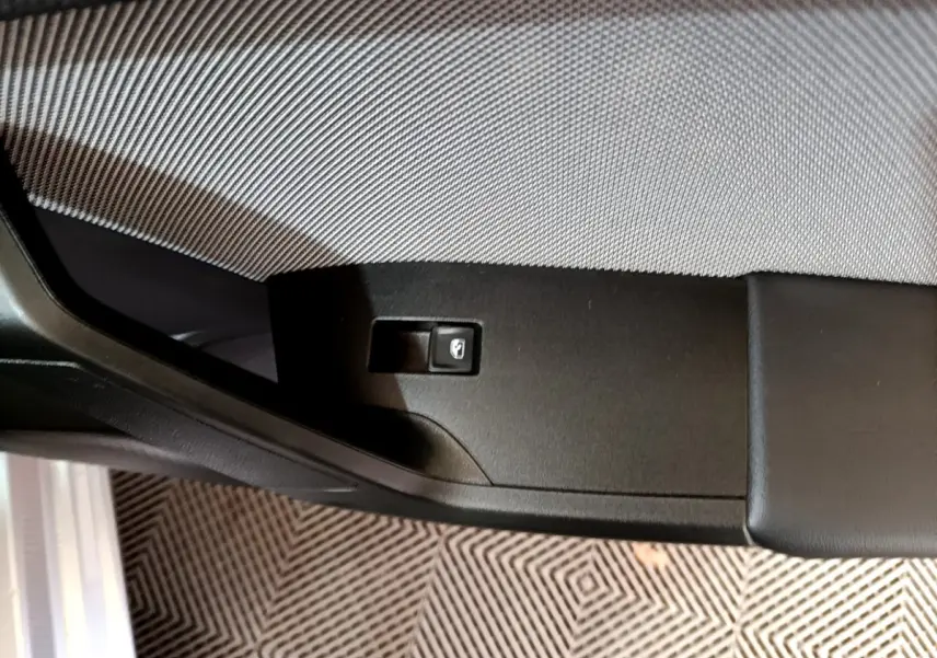 Gros plan sur le panneau de commande de la portière côté gauche d'une SEAT LEON gris foncé 2023.