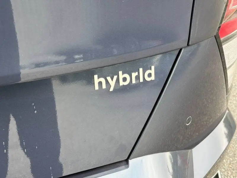 Gros plan sur l'arrière droit d'une Hyundai Kona Cyber Gray métallisé avec le badge "hybrid" visible.