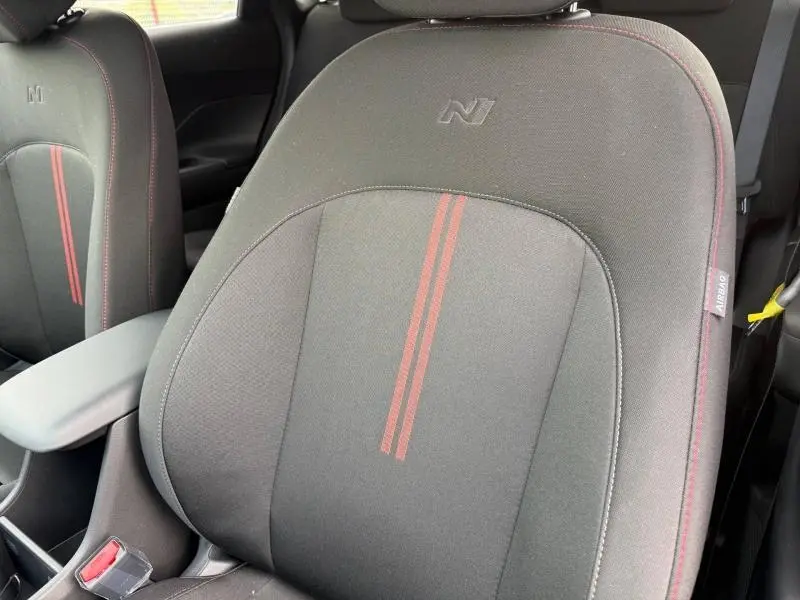 Gros plan sur les sièges avant noirs avec surpiqûres rouges et logo N du Hyundai Kona 2025.