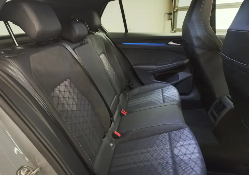 Vue latérale intérieure des sièges arrière de la Volkswagen Golf 2.0 TDI R-Line gris lunaire avec sellerie tissu et cuir noir.