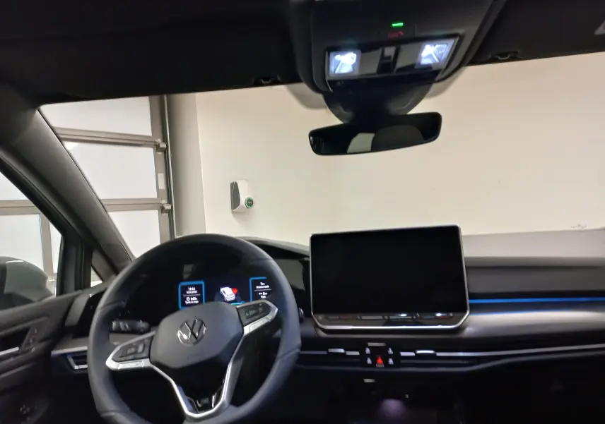 Vue intérieure du poste de conduite de la Volkswagen Golf 2.0 TDI R-Line 2026 avec volant multifonction et écran tactile central.