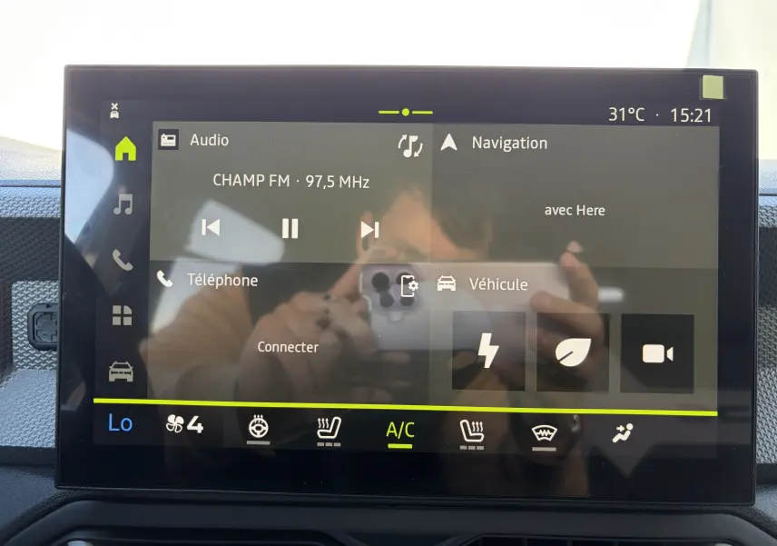 Écran tactile central 10 pouces du Dacia Duster III affichant radio, navigation et commandes climatisation.