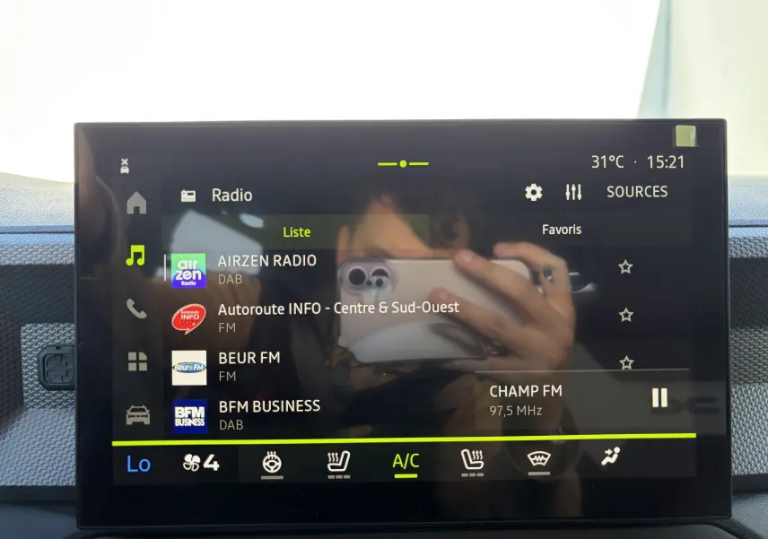 Écran tactile central 10 pouces du Dacia Duster III hybride affichant la liste des radios avec interface moderne.