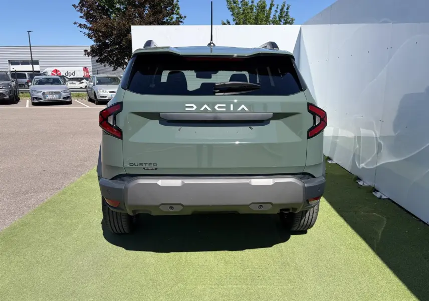 Vue arrière d'un Dacia Duster III hybride 2026 en kaki lichen avec feux arrière LED et pare-chocs gris.