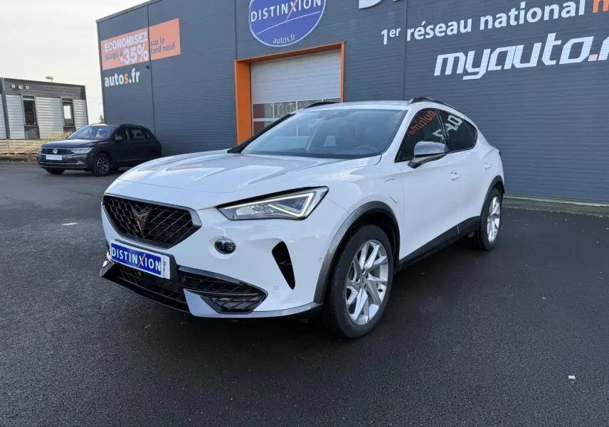 Vue 3/4 avant d'un CUPRA Formentor blanc 2023 hybride rechargeable, avec jantes alliage et calandre noire distinctive.