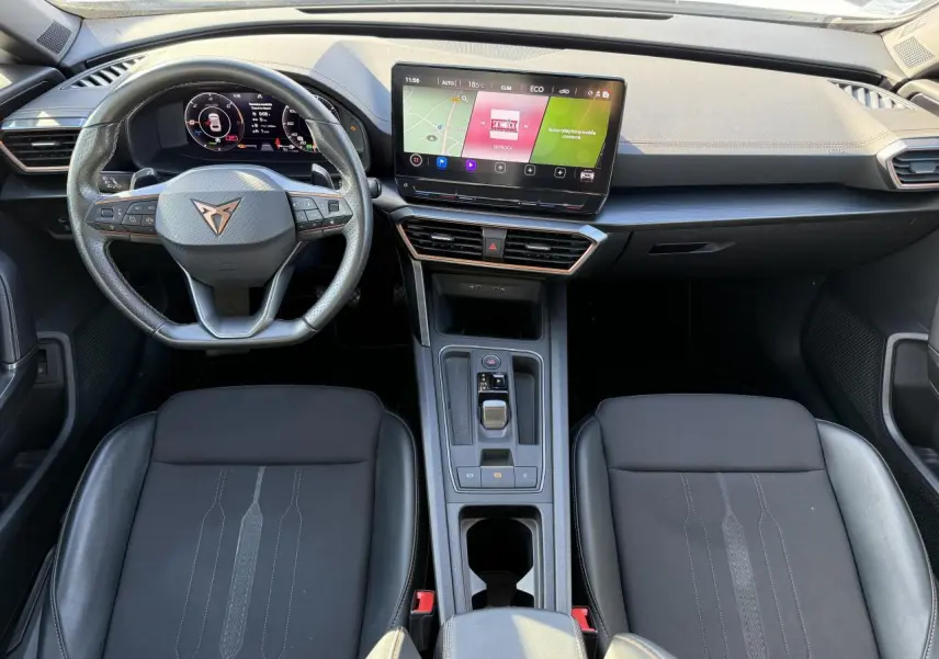 Vue intérieure avant du CUPRA Formentor 1.4 e-Hybrid 2023, tableau de bord moderne avec écran tactile et volant multifonction.