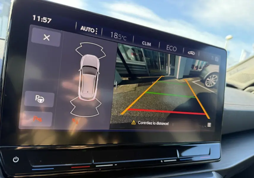 Écran tactile intérieur du CUPRA Formentor blanc 2023 montrant la caméra de recul et l'aide au stationnement.