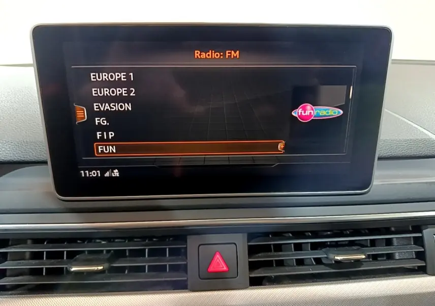 Écran tactile central de l'Audi A4 40 TDI 2018 affichant la liste des radios FM, intérieur noir.
