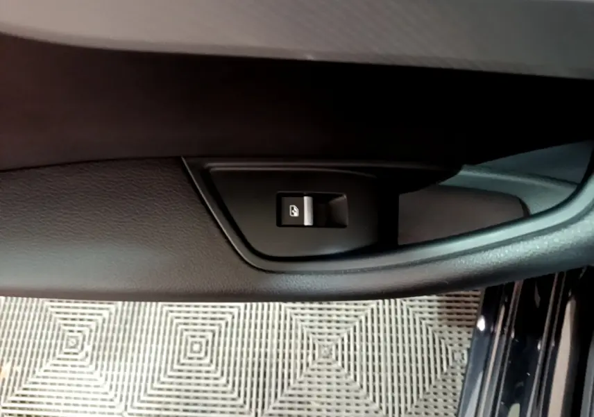 Gros plan sur la commande de verrouillage de porte côté gauche de l'Audi A4 noire, intérieur en cuir noir.