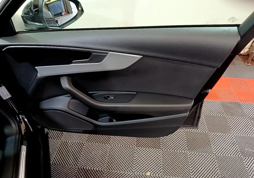 Vue rapprochée de la porte côté gauche noire de l'Audi A4 40 TDI 2018 avec garniture grise et poignée intégrée.