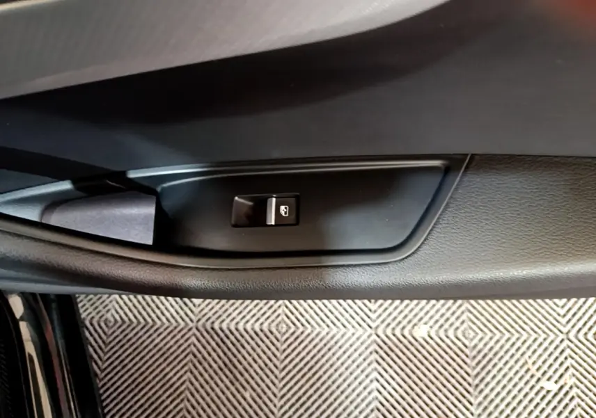 Bouton de commande de lève-vitre sur la porte intérieure noire de l'Audi A4 40 TDI 2018, côté gauche.