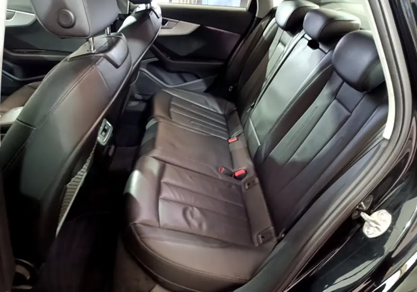 Vue intérieure côté droit des sièges arrière en cuir noir de l'Audi A4 40 TDI 2018 avec appuie-têtes réglables.