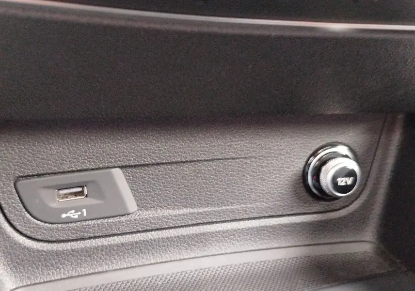 Gros plan sur la prise USB et l’allume-cigare 12V dans l’habitacle noir de l’Audi Q2 35 TFSI S line 2023.