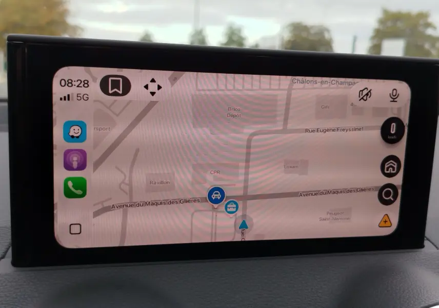 Écran central de navigation de l'Audi Q2 35 TFSI 2023, affichant une carte avec interface moderne et icônes colorées.