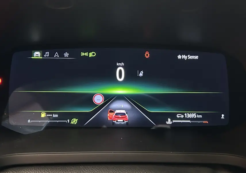 Affichage numérique du tableau de bord du Renault Captur rouge flamme, montrant la voiture à l'arrêt avec la porte gauche ouverte.