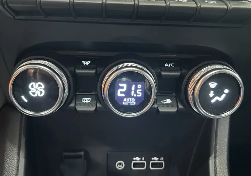 Gros plan sur les commandes de climatisation du Renault Captur 2024, affichant 21,5°C en mode automatique.