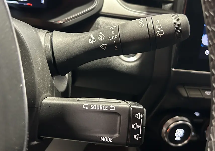 Gros plan sur les commandes au volant du Renault Captur TCE 90CH TECHNO 2024, détails des leviers de réglage noir.