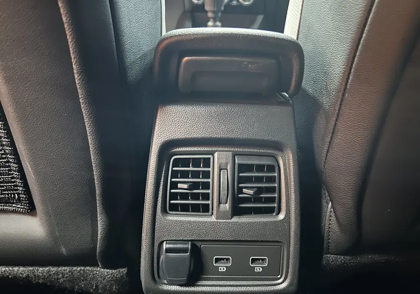 Vue rapprochée des aérateurs arrière et ports USB du Renault Captur TCE 90CH TECHNO rouge flamme métal, intérieur noir cuir.