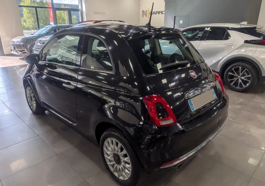 Fiat 500 1.2 69 CH Lounge noire vue en 3/4 arrière droit dans un showroom avec jantes alliage multibranches.