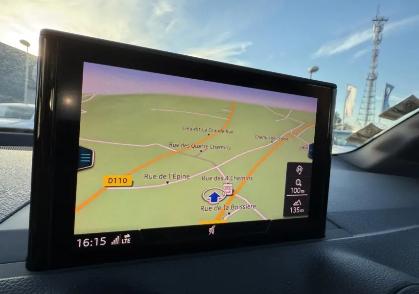 Écran de navigation MMI de l'Audi Q2 noir brillant, affichant une carte routière en intérieur véhicule.