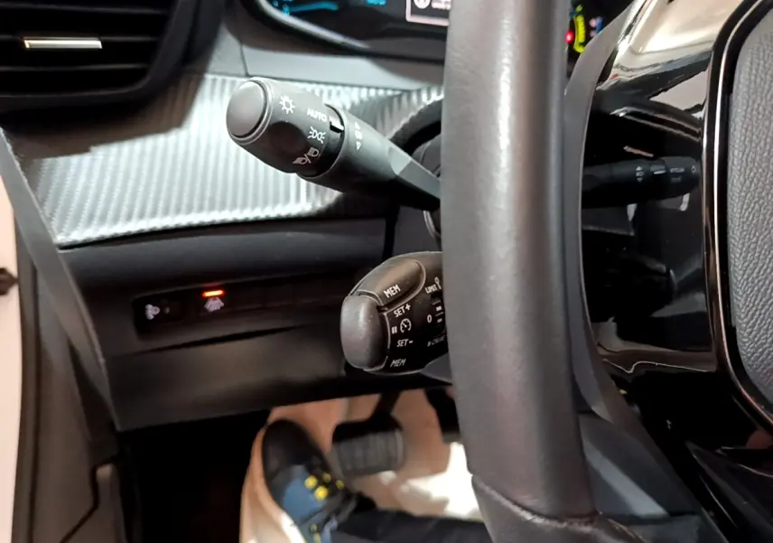 Gros plan sur le volant cuir noir et commandes au volant de la Peugeot 208 électrique Active Business 2021.