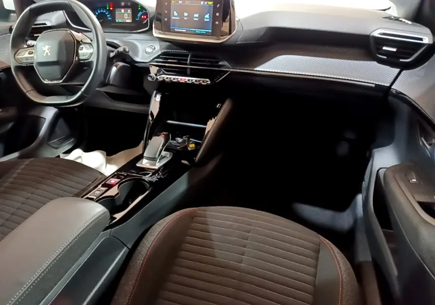 Intérieur noir de la Peugeot 208 Electrique Active Business 2021, vue côté passager avec tableau de bord et écran tactile central.