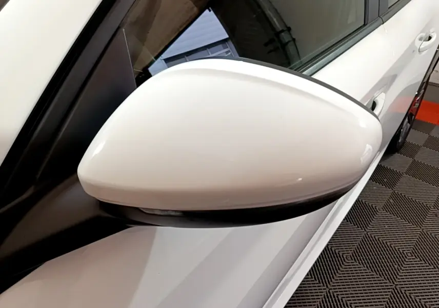 Rétroviseur blanc côté gauche de la Peugeot 208 Electrique Active Business 2021, avec carrosserie blanche visible en arrière-plan.