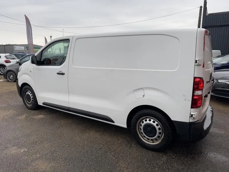 Vue latérale droite d'un utilitaire Citroën Jumpy blanc Banquise de 2018 avec portes arrière battantes et jantes tôle.