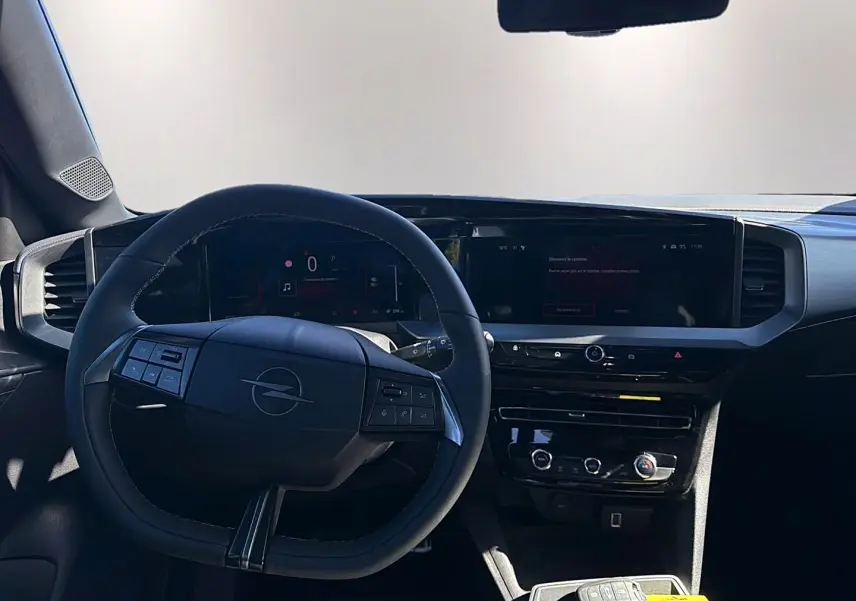 Vue intérieure centrée sur le volant multifonction et l'écran tactile du tableau de bord de l'Opel Mokka Electric gris.