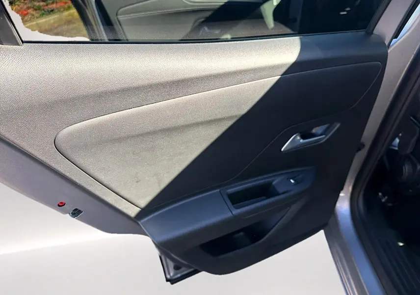 Vue rapprochée de la porte arrière droite grise de l’Opel Mokka Electric 156 gs avec panneau intérieur noir.