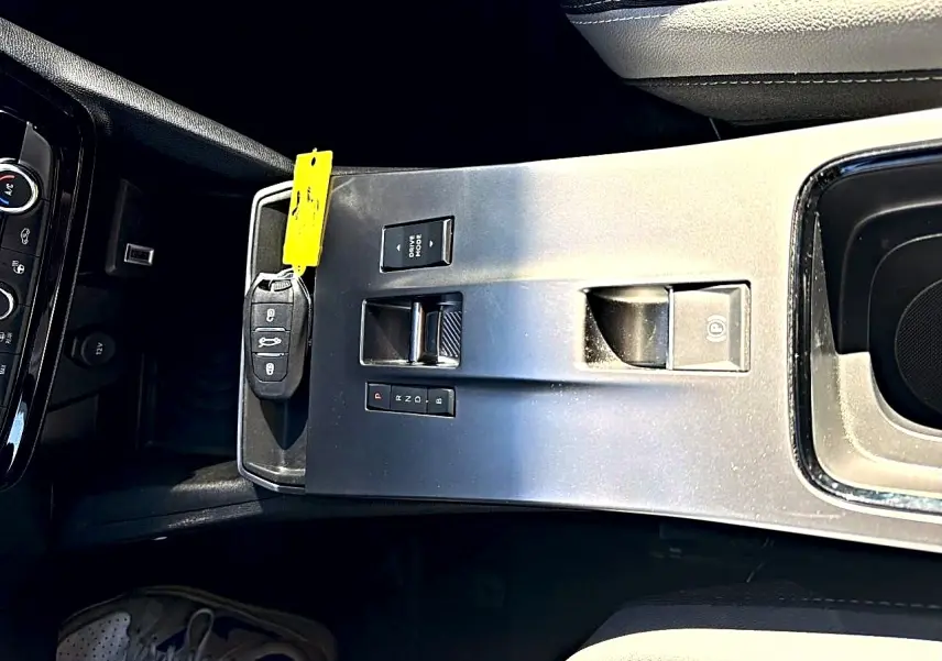 Vue plongeante sur la console centrale grise de l'Opel Mokka Electric 156 GS avec clé et commandes de boîte automatique.