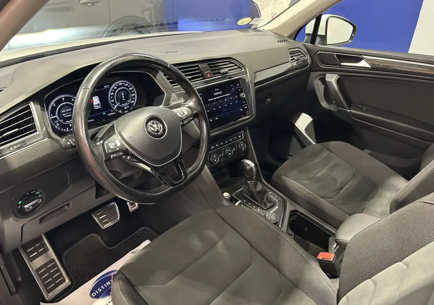 Intérieur noir du Volkswagen Tiguan Allspace 2018, vue de l'habitacle côté conducteur avec tableau de bord et volant visibles.