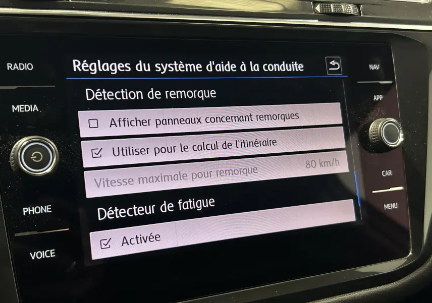 Écran tactile du système d'aide à la conduite du Volkswagen Tiguan Allspace affichant les réglages de détection de remorque et détecteur de fatigue activé.