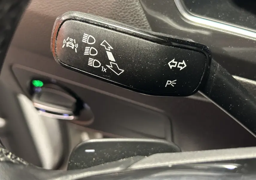 Gros plan sur la manette de clignotants noire du Volkswagen Tiguan Allspace 2018, avec pictogrammes blancs visibles.