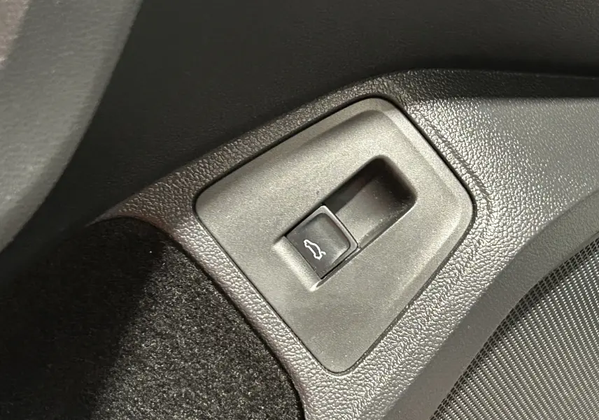 Gros plan sur le bouton d'ouverture du hayon dans l'habitacle noir du Volkswagen Tiguan Allspace blanc 2018.