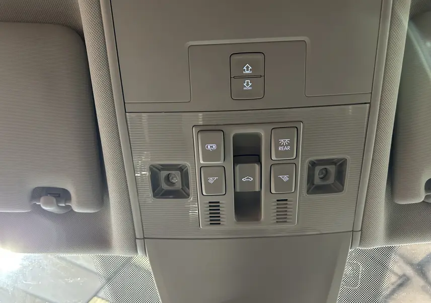 Panneau de commandes de toit ouvrant et éclairage intérieur gris clair dans un Volkswagen Tiguan Allspace blanc.