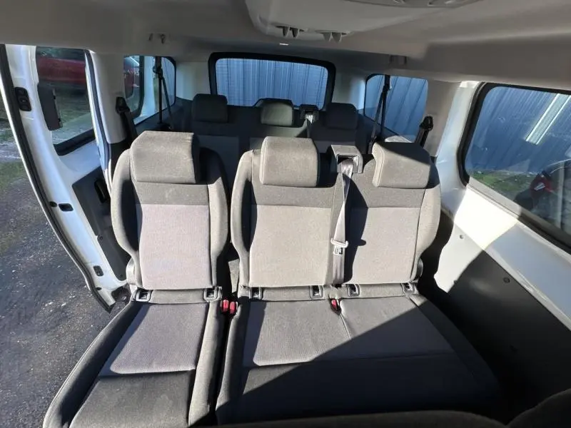 Vue intérieure arrière du Citroën Jumpy blanc, montrant les sièges en tissu Mica sur trois rangs.