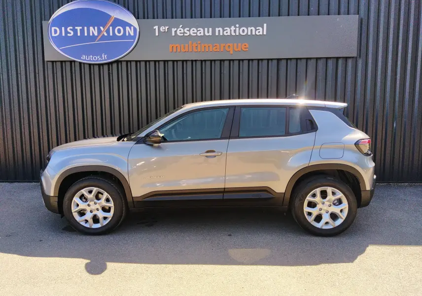 Vue de profil côté gauche d'un Jeep Avenger eHYBRID gris 2025 avec jantes alliage et détails noirs contrastants.