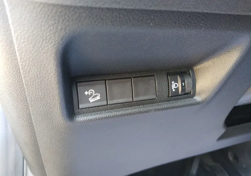 Gros plan sur les commandes de réglage d'éclairage et de régulateur de vitesse dans un Jeep Avenger gris eHYBRID 2025.