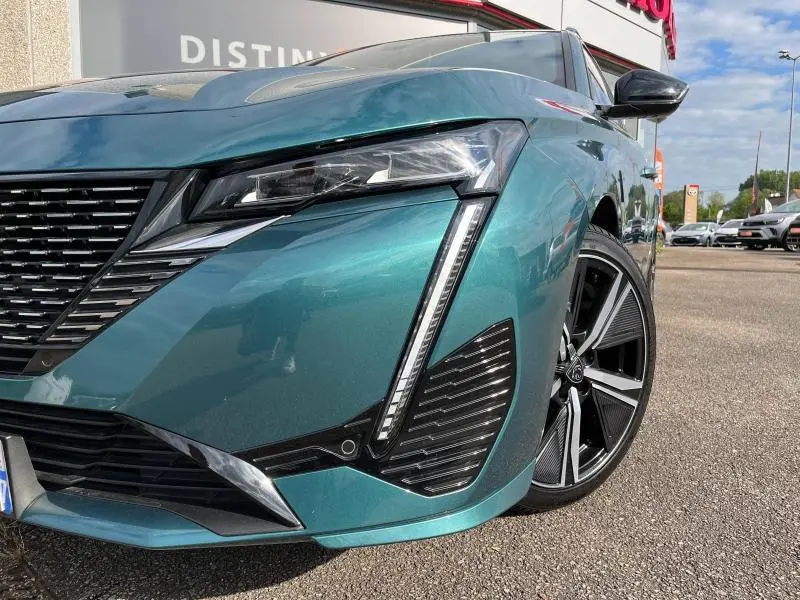 Gros plan sur l'avant droit bleu Avatar métallisé du Peugeot 308 SW 2023 avec phares LED et jante alliage noire.