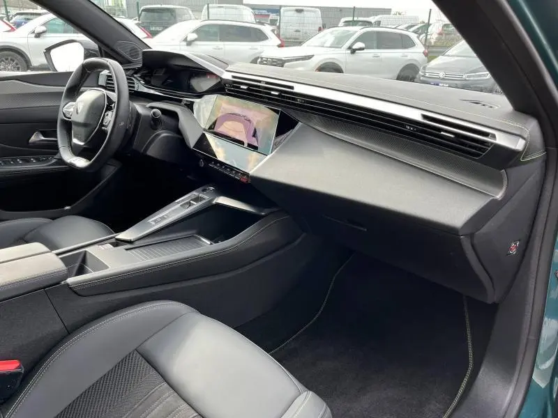 Intérieur avant droit de la Peugeot 308 SW 2023 Bleu Avatar, tableau de bord moderne avec écran tactile et volant multifonction.