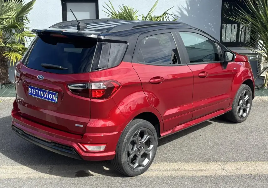 Vue 3/4 arrière droite du Ford EcoSport rouge métallisé avec toit noir et vitres arrière surteintées.
