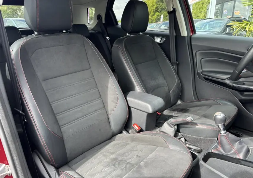 Intérieur avant du Ford EcoSport rouge 2019, sièges cuir/tissu noirs avec surpiqûres rouges et levier de vitesse manuel.
