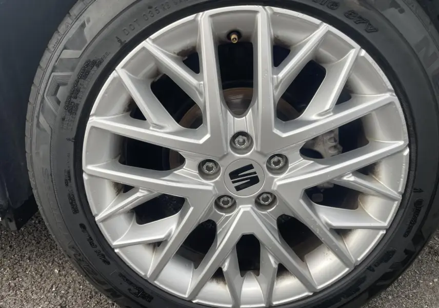 Gros plan sur la jante alliage argentée avec logo SEAT, roue avant d'une SEAT Ibiza blanche 2025.