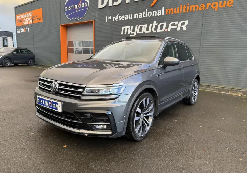 Volkswagen Tiguan gris Indium métallisé vu en 3/4 avant droit avec jantes alliage et calandre R-Line.