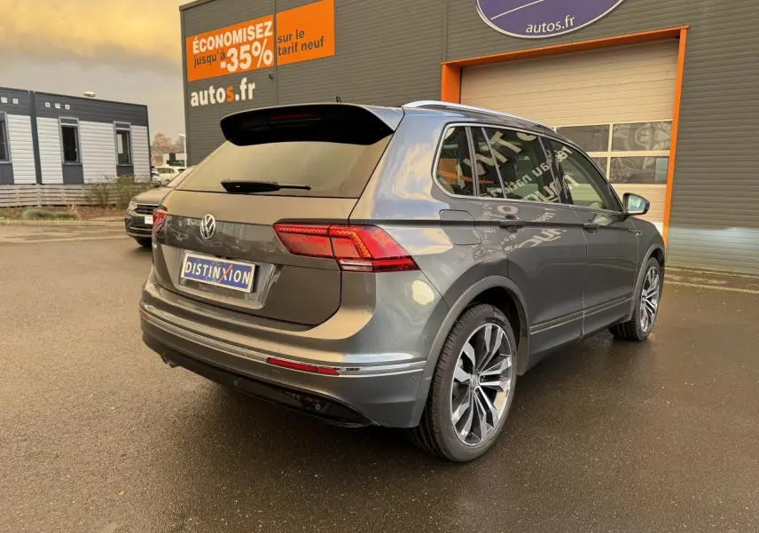 Volkswagen Tiguan gris Indium métallisé vu en 3/4 arrière droit, avec jantes alliage et feux arrière LED.