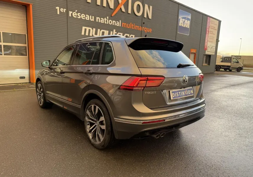 Vue 3/4 arrière droite du Volkswagen Tiguan gris Indium métallisé avec jantes alliage 20 pouces et spoiler R-Line.